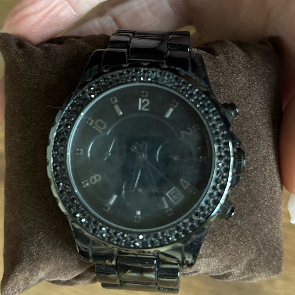 Michael Kors black metal watch w black rhinestones around watch face.
